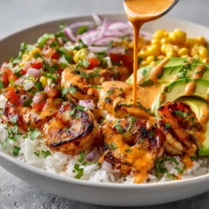 A close-up shot of a healthy shrimp bowl, showcasing the perfectly grilled shrimp, diced avocado, and fresh cilantro on a bed of quinoa.