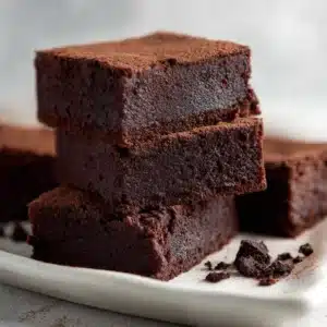 Close up of 3 ingredient banana brownies showing a thick, fudge-like center and a smooth matte baked top.