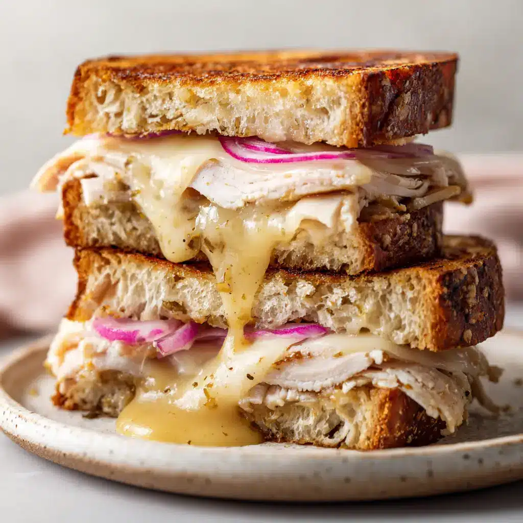 A detailed view of the crispy, butter-toasted artisan bread and the glossy honey dijon mustard sauce dripping slightly from the Turkey Dijon Melt.