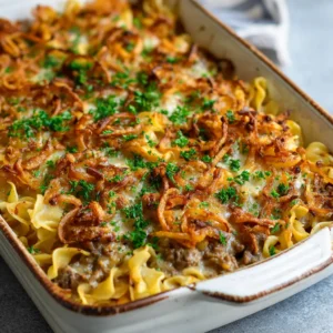Close-up of freshly baked French Onion Beef Casserole showing the light brown sauce and green parsley flakes.