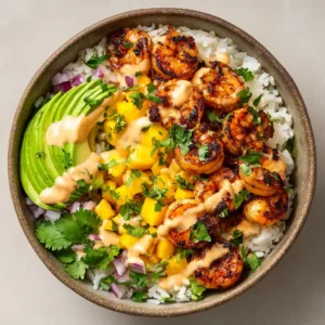 A handheld smartphone photo of Shrimp and Avocado Bowls with smoky charred shrimp and vibrant mango salsa on a white rice base.