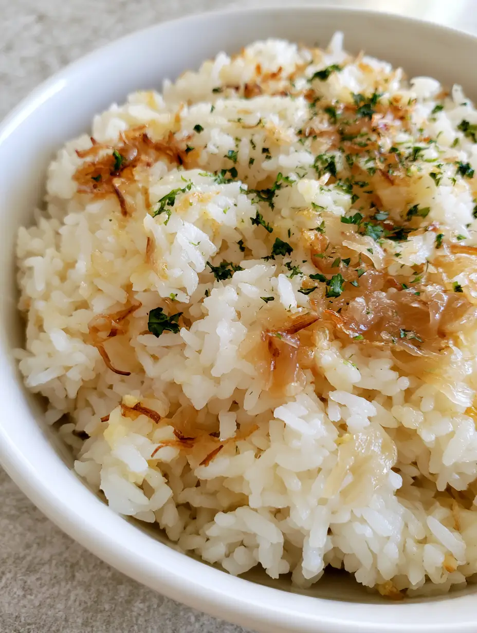 Close-up of Golden Onion Butter Jasmine Rice grains glistening with melted butter and toasted noodles.