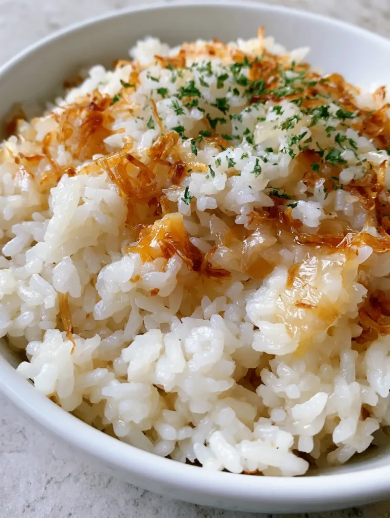 A handheld smartphone photo of Golden Onion Butter Jasmine Rice highlighting the soft caramelized onion bits.